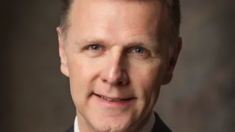 Portret van Michel van Roon in een donker pak met lichtblauwe stropdas