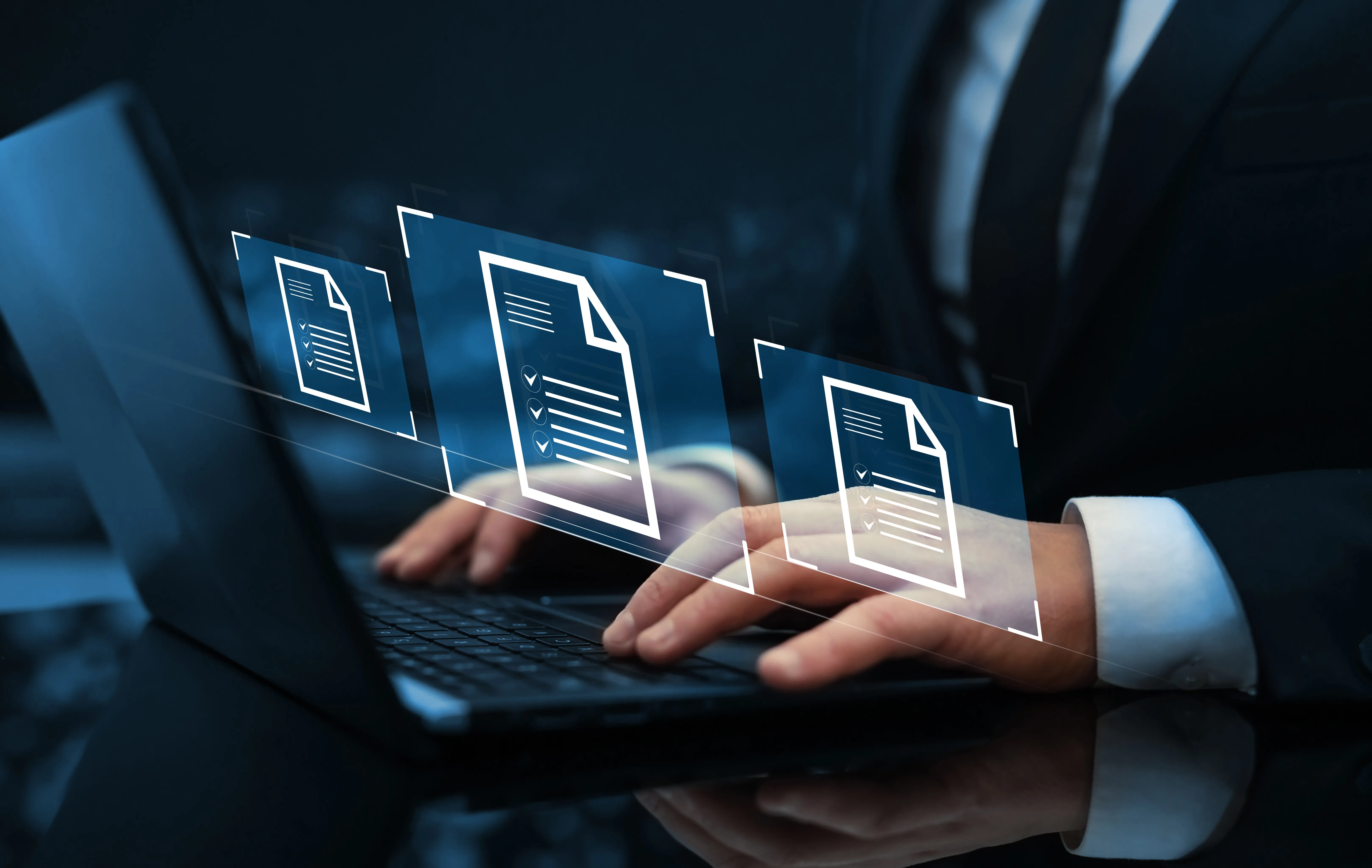 Hands typing on a laptop with digital documents floating above the keyboard